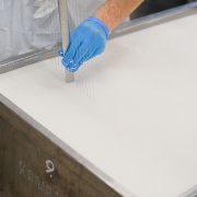 Trabalhador utiliza uma ferramenta durante a produção de queijo em uma unidade de laticínios.