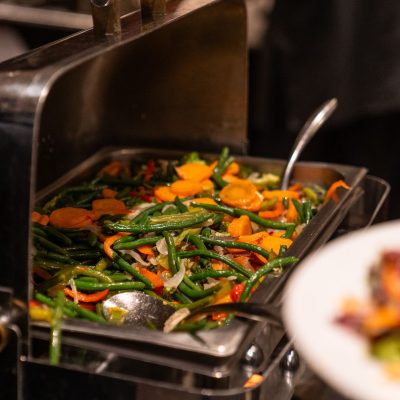 Travessa de buffet com variedade de vegetais preparados, pronta para ser servida.